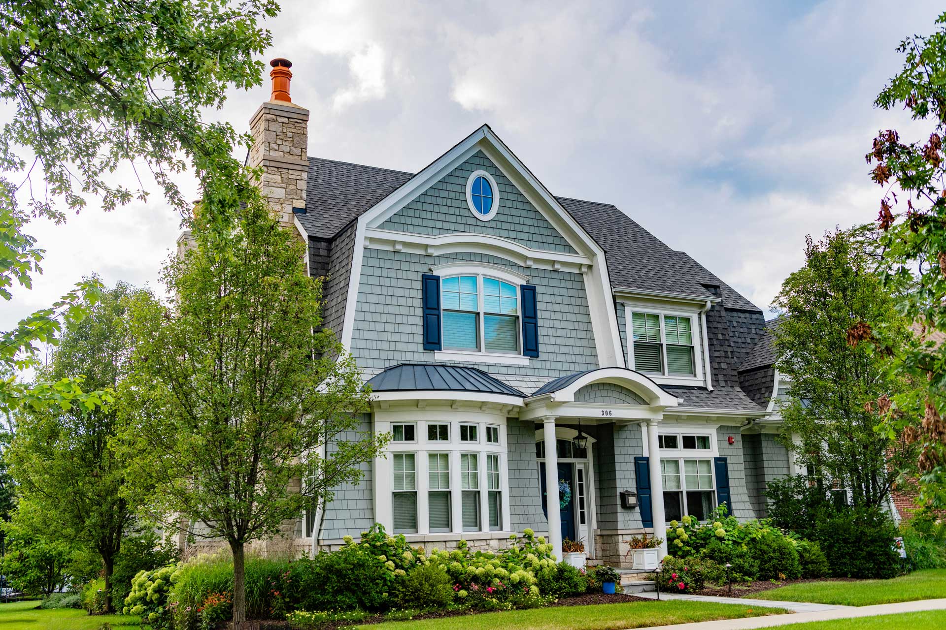 Stunning Virginia home with a light blue exterior surrounded by green trees
